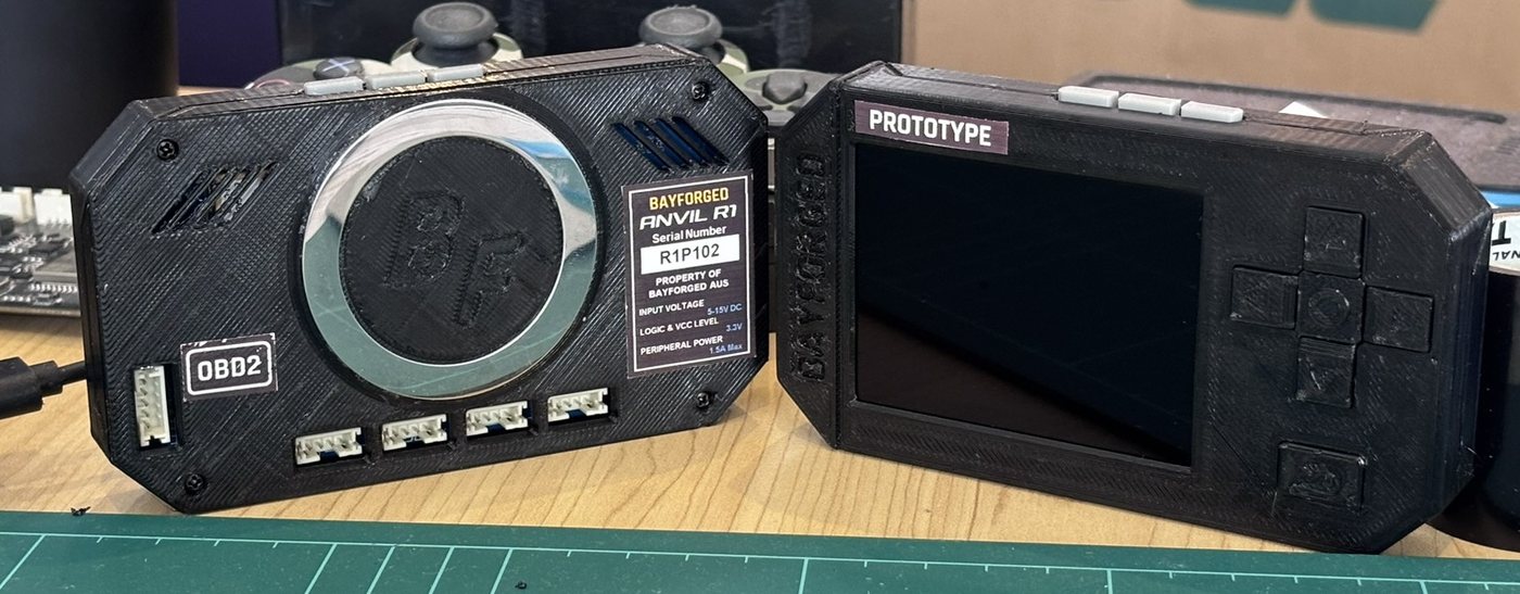 Two third-generation Anvil prototypes side by side: the back, with its OBD2 and expansion ports, and the front, with its screen and buttons
